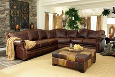 a living room filled with furniture and a large stone wall behind the couch is a coffee table