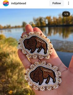 someone is holding two beaded bear brooches in their left hand and the other one has an embroidered bear on it