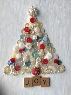 a christmas tree made out of buttons and wooden blocks with the word joy spelled on it