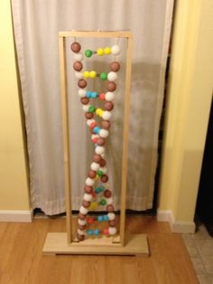 a wooden frame filled with lots of different colored candies on top of a hard wood floor