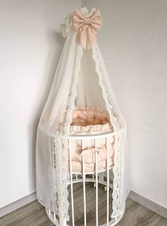 a white crib with a pink bow on top