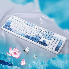 a computer keyboard sitting on top of a blue and white background with water lilies