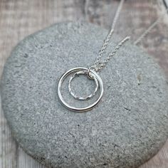 STERLING SILVER 2 CIRCLE NECKLACE This lovely necklace is hand made from 2 circles of Sterling Silver.  The largest circle has a smooth finish and measures approximately 20 mm in diameter, the smaller twisted circle measures approximately 12 mm in diameter.  This necklace can be finished with either a 16, 18 or 20 Inch cable chain.  Please note: This item is made to order.  Packaging: Your item will be wrapped in tissue paper, placed in a branded Jewellery by Jo Gift box or bag and packaged in a Double Circle Necklace, Twisted Necklace, Silver Jewelry Design, Necklace Ring, Initial Pendant Necklace, Formal Outfits, Silver Circle, Lovely Necklace, Circle Necklace