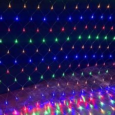 colorful lights are strung up on the ground in front of a fenced off area