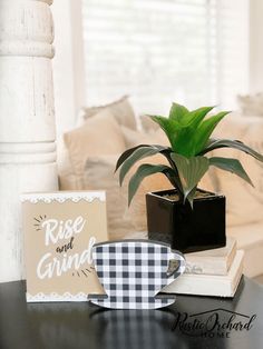 a black and white checkered coffee cup sitting on top of a table next to a book