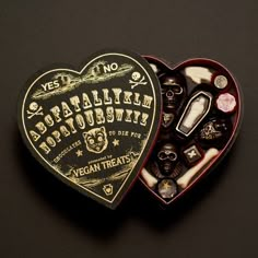 two heart shaped boxes filled with different types of candies