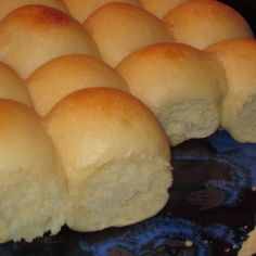 rolls are being cooked in the oven on top of a blue plate with black cloth