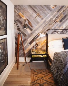 a bed room with a neatly made bed and pictures on the wall