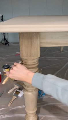 someone is painting the top of a table