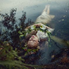 a woman laying on the ground next to water