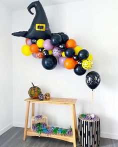 a room with balloons and decorations on the wall, including a witch's hat