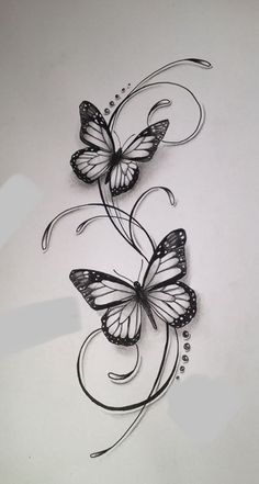 two butterflies with swirls and dots on white paper