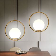 two circular lights hanging over a wooden table