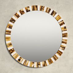 a round mirror with gold and white stripes