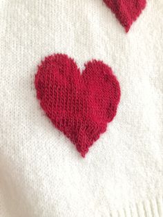 two knitted hearts on a white sweater