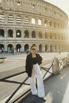 a woman standing in front of the colossion with her hands on her hips