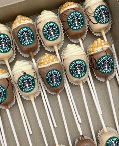 starbucks cupcakes and marshmallow pops are arranged on sticks in a box