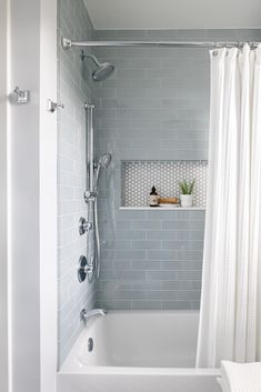 a white bath tub sitting next to a shower