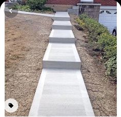 there is a set of concrete steps leading up to the garage door on this street