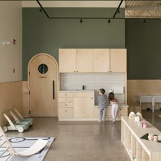 two children are standing in the middle of a large room with chairs and other furniture