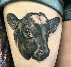 a black and white photo of a cow's face on the thigh, with an ear tag