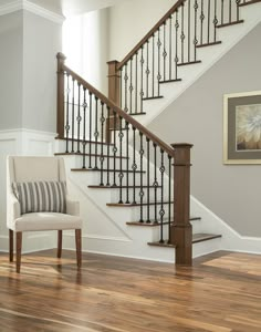 a chair sitting in front of a stair case on top of a hard wood floor