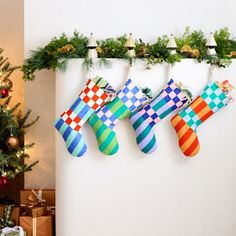 christmas stockings hanging on the wall next to a christmas tree