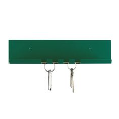 two keys hanging from the end of a green shelf with three key hooks on it