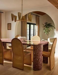 the dining room table is surrounded by wicker chairs and an oval shaped chandelier