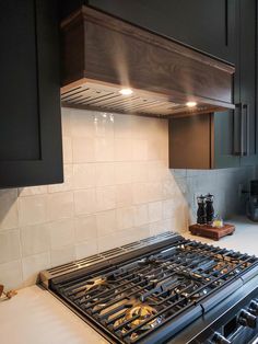 a stove top oven sitting inside of a kitchen next to a wooden cabinet and counter