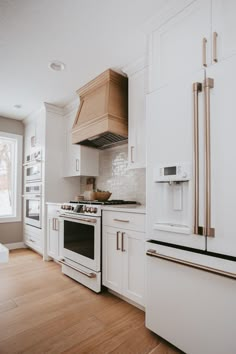 a kitchen with white cabinets and wood floors