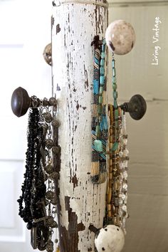 an old door is decorated with beads and necklaces hanging from it's side