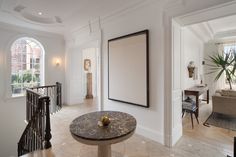 a living room filled with furniture and a large poster hanging on the wall next to a stair case