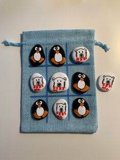 six penguin buttons on a blue cloth bag