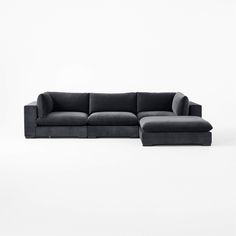 a black sectional sofa sitting on top of a white floor