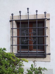 a window with iron bars on the side of it