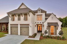 a white house with two garages in front of it