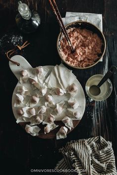 marshmallows are arranged on a plate next to a bowl of chocolate pudding