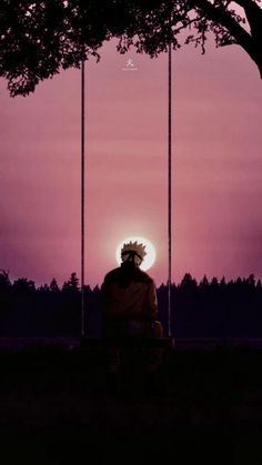 a person sitting on a swing in front of the sun at night with trees and pink sky