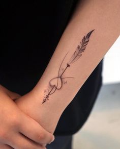 a woman's arm with an arrow tattoo on it