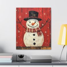 a painting of a snowman wearing a hat and scarf on a red wooden background