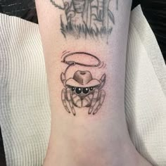 a crab tattoo on the ankle with an angel above it and a devil in the background