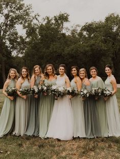 a group of women standing next to each other on top of a lush green field