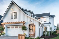 a white house with two garages and an attached porch