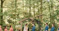 a bride and groom standing in front of their wedding party at the end of an outdoor ceremony