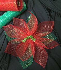 two rolls of red and green mesh with a poinsetti