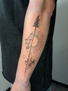 a man with a tattoo on his arm holding a pine tree and sun in the background