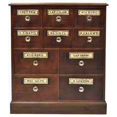 an old wooden cabinet with many drawers and brass letters on the front, including name plates