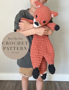 a young boy is holding a crochet stuffed animal that looks like a fox