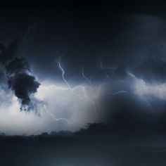 there is a large cloud with lightning coming out of it and some dark clouds in the background